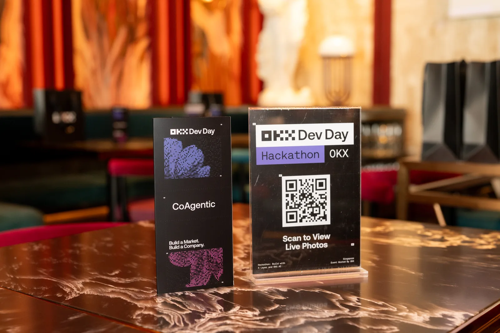 CoAgentic name card and OKX Dev Day QR stand at the Singapore venue